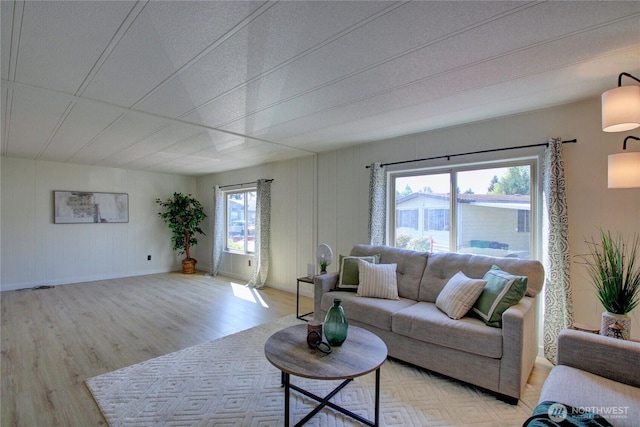living area featuring light wood-style floors and baseboards