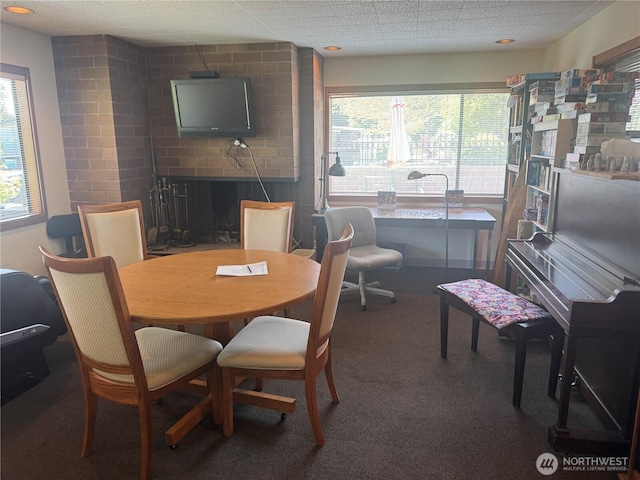 carpeted dining area with a brick fireplace and a healthy amount of sunlight