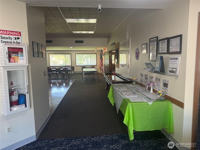 corridor with baseboards and visible vents