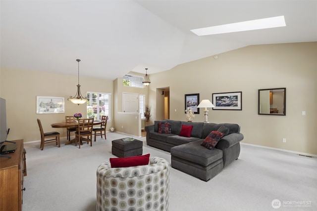 living room featuring vaulted ceiling, a skylight, carpet floors, and baseboards