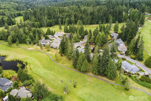 aerial view of property's location with nearby suburban area, a golf course, a nearby body of water, and a heavily wooded area