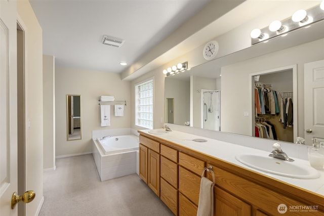 full bathroom featuring a garden tub, a stall shower, double vanity, baseboards, and a spacious closet