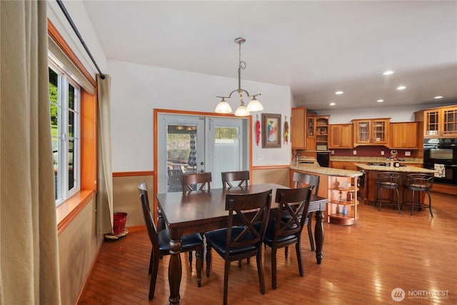dining room with wood-type flooring, a chandelier, and recessed lighting