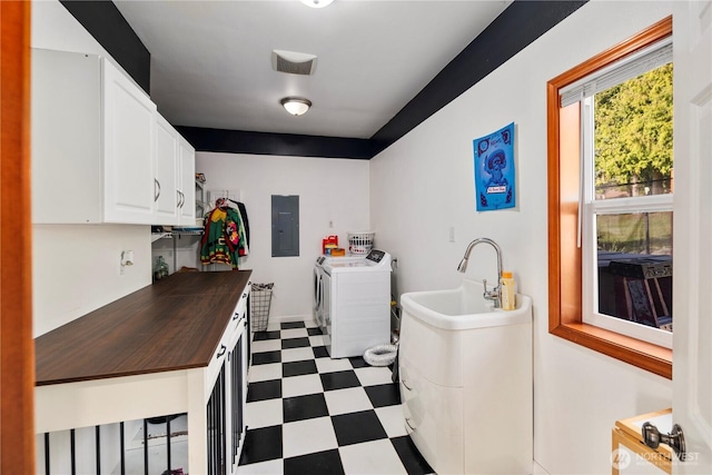 laundry area with dark flooring, washer and clothes dryer, cabinet space, and electric panel