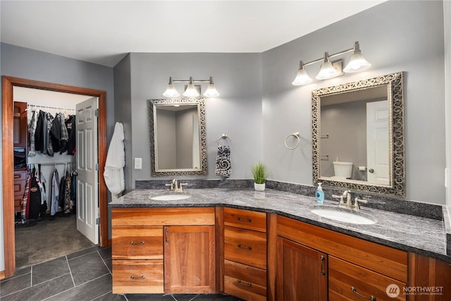bathroom featuring double vanity, a spacious closet, tile patterned floors, and toilet