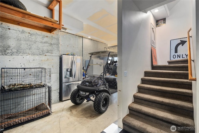 stairs featuring unfinished concrete floors