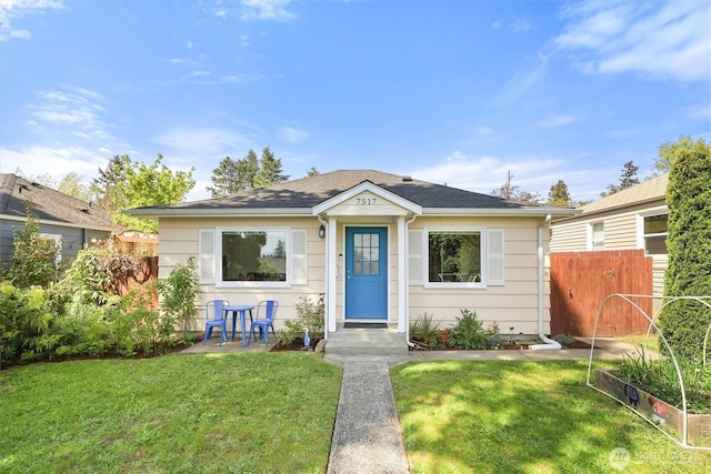 bungalow with a vegetable garden, fence, and a front yard