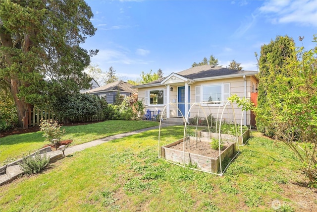 bungalow-style house with a vegetable garden and a front yard