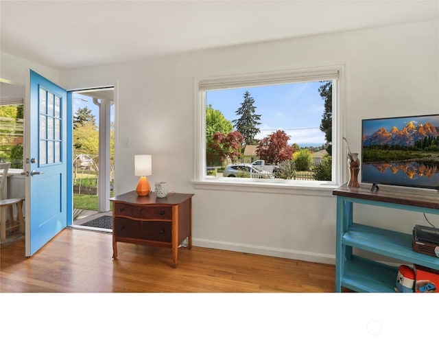 foyer entrance with wood finished floors and baseboards