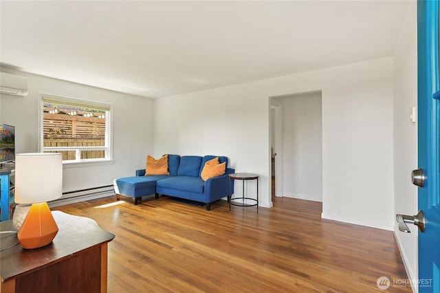 living room featuring a baseboard radiator, a wall unit AC, and wood finished floors