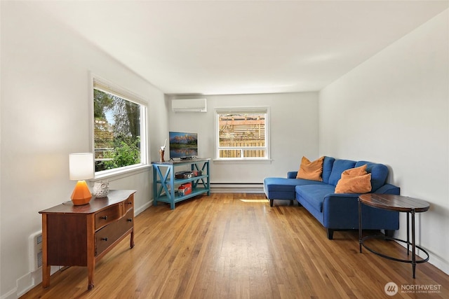 living area with light wood finished floors, baseboards, a baseboard heating unit, and an AC wall unit