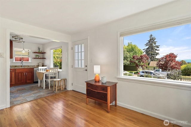 interior space with a wealth of natural light, baseboards, and light wood-type flooring