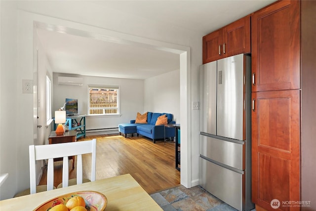 kitchen featuring freestanding refrigerator, open floor plan, baseboards, a baseboard heating unit, and a wall mounted AC