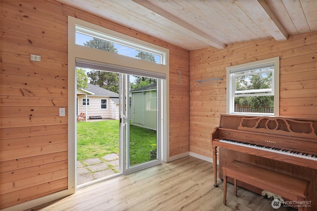 entryway with light wood finished floors, wooden ceiling, wooden walls, and beamed ceiling