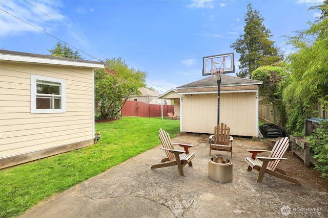 view of patio / terrace featuring an outdoor structure, a fire pit, a storage shed, and a fenced backyard