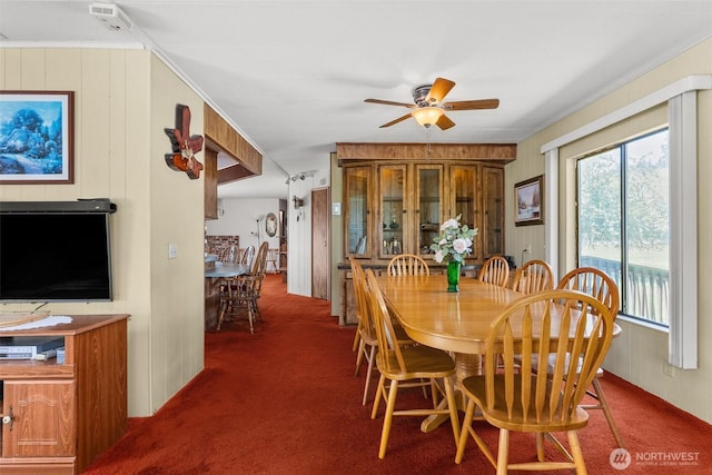 carpeted dining area with ceiling fan