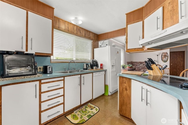 kitchen featuring a sink, white appliances, tasteful backsplash, under cabinet range hood, and white cabinetry