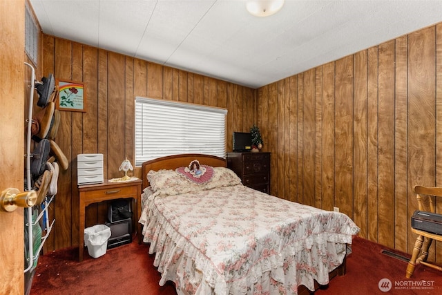 bedroom featuring wood walls and carpet floors
