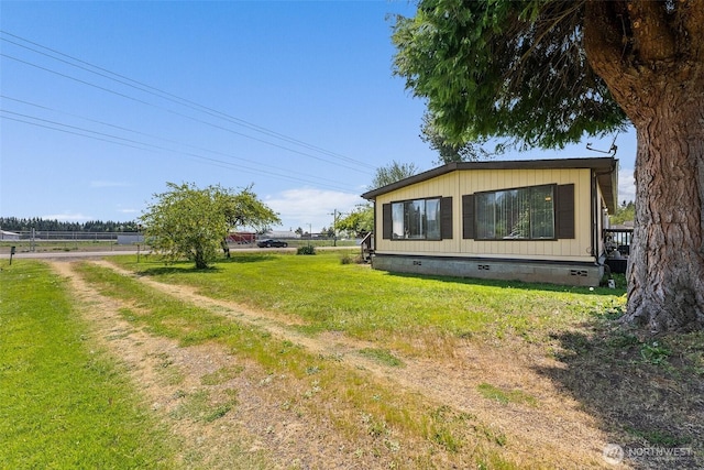 view of side of home featuring a yard and crawl space