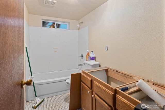 bathroom with toilet, tub / shower combination, a textured wall, and tile patterned flooring
