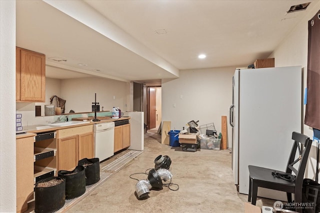 kitchen featuring white appliances, light brown cabinetry, light countertops, a sink, and concrete floors