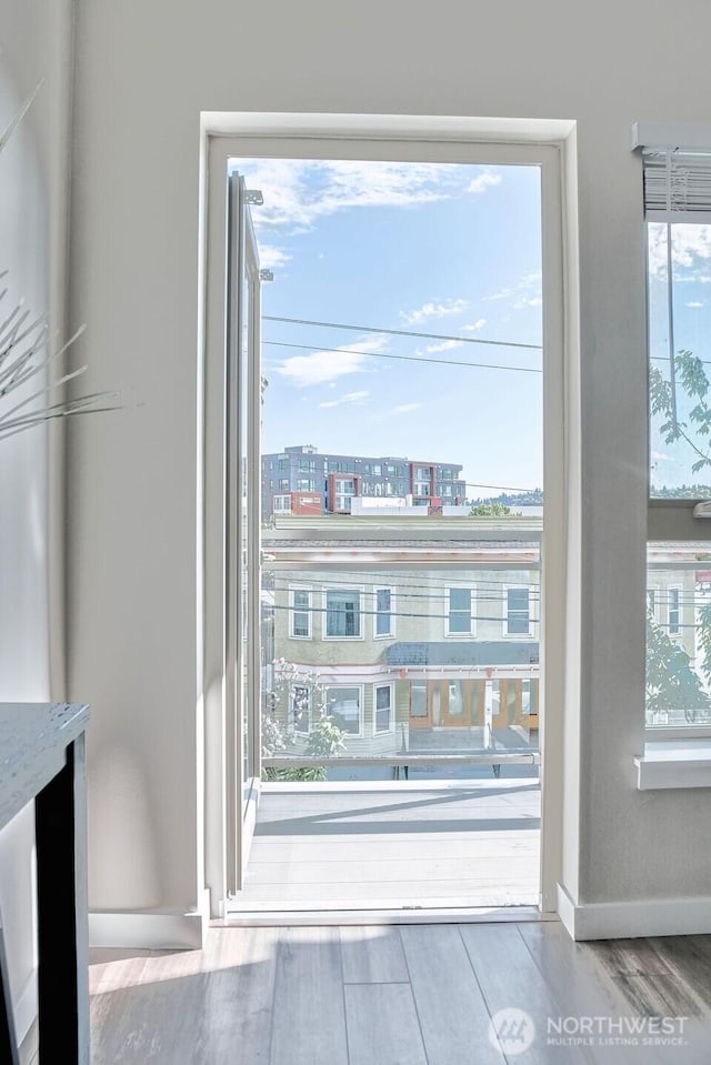 1760 NW 56th St Unit 310, Seattle, WA 98107 - doorway to outside with wood finished floors, healthy amount of natural light, and baseboards
