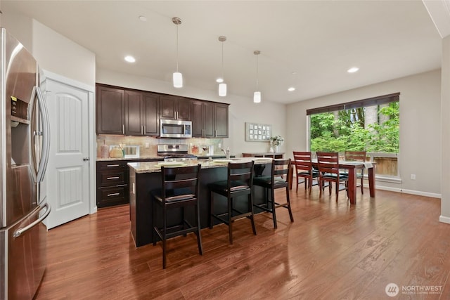 1517 Onyx St SE, Olympia, WA 98501 - kitchen with dark brown cabinets, backsplash, appliances with stainless steel finishes, and dark wood-type flooring