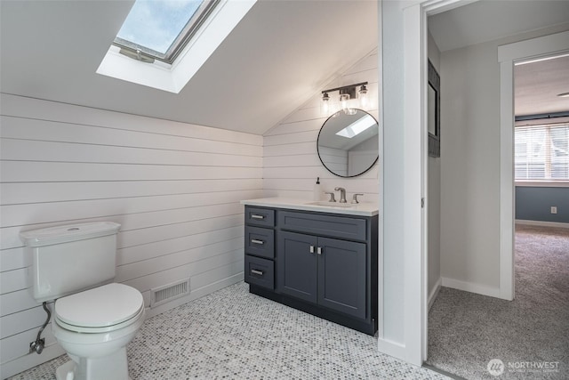 2656 168th Ave NE, Bellevue, WA 98008 - half bath with a skylight, vaulted ceiling, vanity, wood walls, and toilet