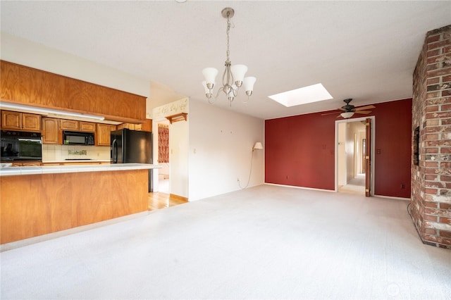 524 Carl Way, Aberdeen, WA 98520 - kitchen with black appliances, tile counters, a skylight, brown cabinetry, and open floor plan