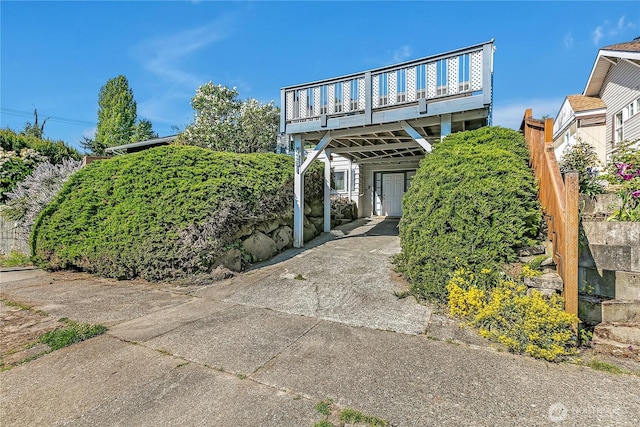7351 32nd Ave SW, Seattle, WA 98126 - view of front facade with a carport, a wooden deck, and driveway
