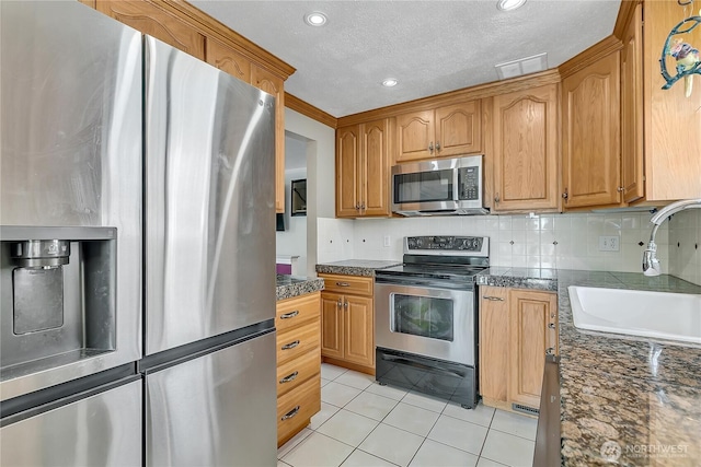 7351 32nd Ave SW, Seattle, WA 98126 - kitchen featuring appliances with stainless steel finishes, a sink, light tile patterned floors, dark countertops, and recessed lighting