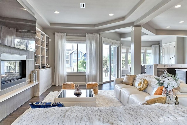 3319 Burnett Ave N, Renton, WA 98056 - living area featuring a glass covered fireplace, recessed lighting, wood finished floors, and decorative columns