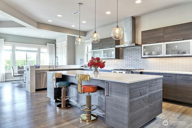 3319 Burnett Ave N, Renton, WA 98056 - kitchen with wall chimney exhaust hood, appliances with stainless steel finishes, a kitchen island, modern cabinets, and recessed lighting