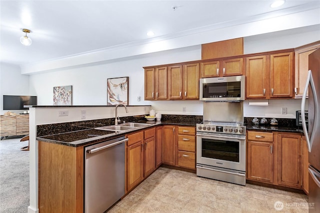 1015 Railroad Ave Unit 405, Bellingham, WA 98225 - kitchen featuring appliances with stainless steel finishes, a sink, brown cabinets, a peninsula, and dark stone countertops