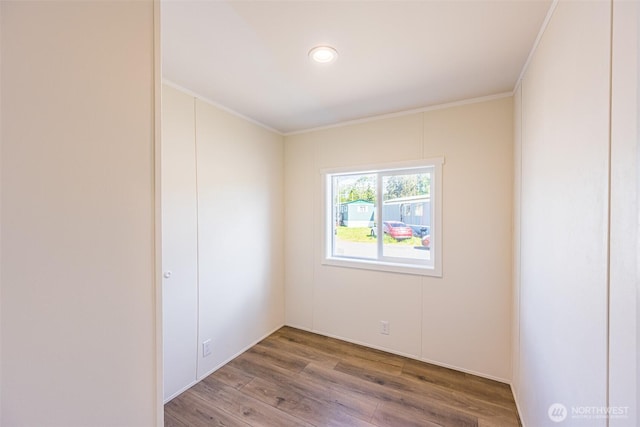 empty room featuring crown molding and wood finished floors