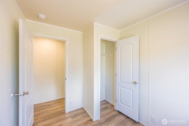 unfurnished bedroom with light wood finished floors and ornamental molding