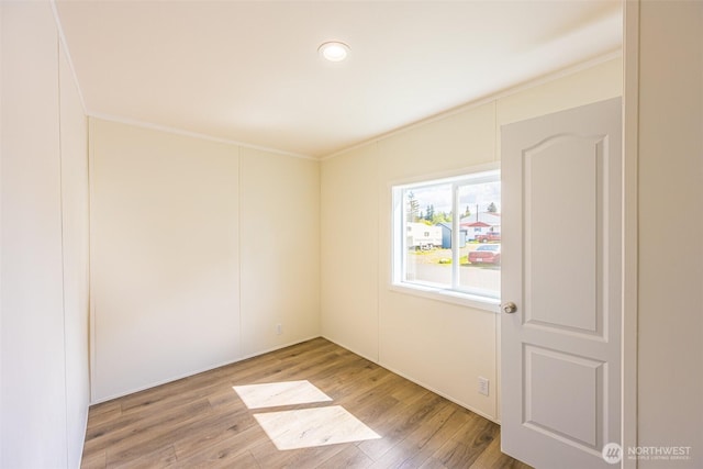 unfurnished room featuring ornamental molding and wood finished floors