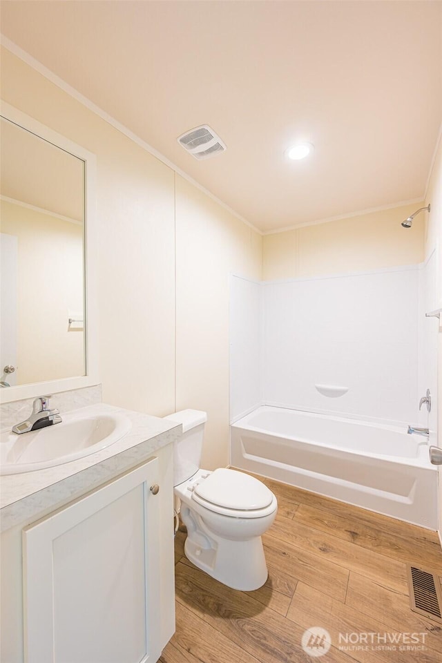 full bath with toilet, visible vents, wood finished floors, and shower / bath combination