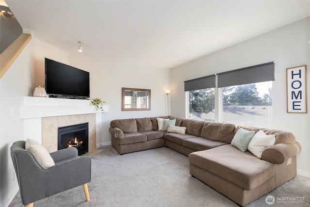 living room featuring carpet floors, a tiled fireplace, and baseboards