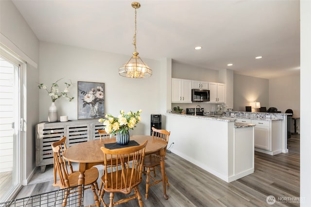 dining area with wood finished floors, recessed lighting, baseboards, and a chandelier