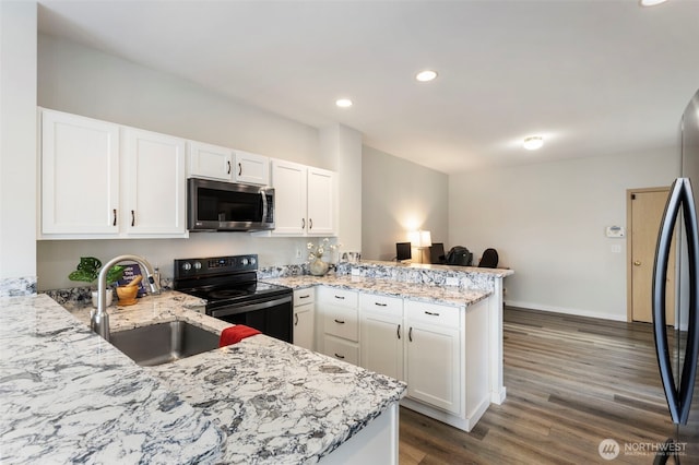 kitchen with black appliances, a sink, a peninsula, white cabinetry, and dark wood-style flooring