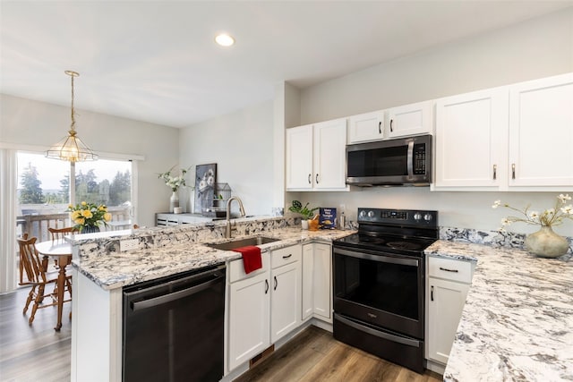 kitchen featuring black electric range oven, stainless steel microwave, dishwashing machine, a sink, and a peninsula