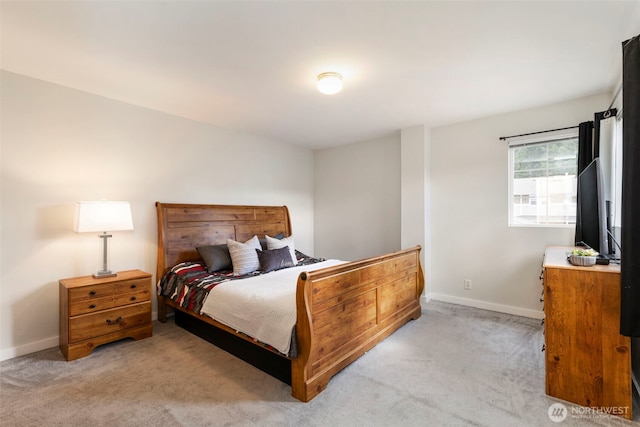 bedroom with light colored carpet and baseboards
