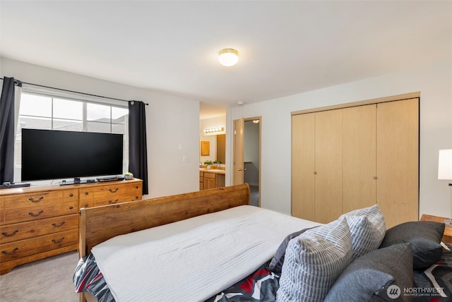 bedroom with a closet, light carpet, and ensuite bathroom