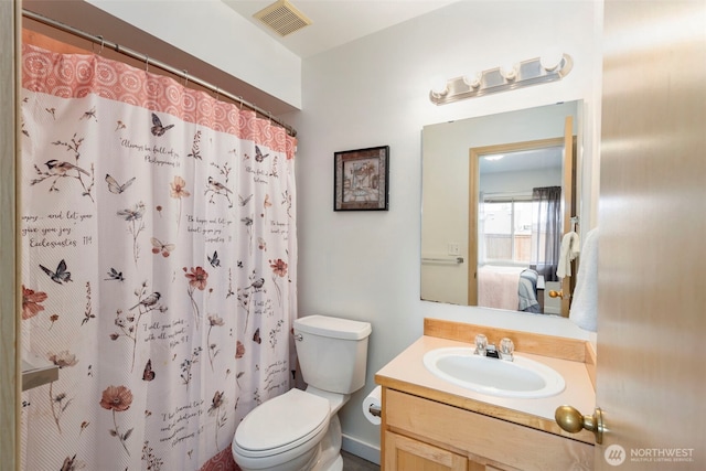 ensuite bathroom with toilet, vanity, and a shower with shower curtain