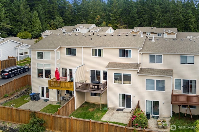 back of house with a shingled roof, a patio, and a fenced backyard