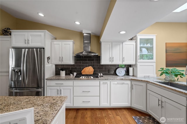 10811 164th Pl NE, Redmond, WA 98052 - kitchen with stainless steel appliances, wall chimney range hood, a sink, white cabinets, and decorative backsplash