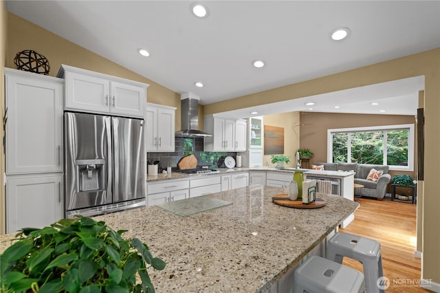10811 164th Pl NE, Redmond, WA 98052 - kitchen featuring stainless steel appliances, wall chimney range hood, white cabinetry, light stone counters, and decorative backsplash