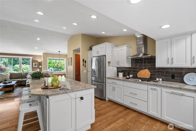 10811 164th Pl NE, Redmond, WA 98052 - kitchen with wall chimney range hood, appliances with stainless steel finishes, open floor plan, white cabinets, and light wood finished floors