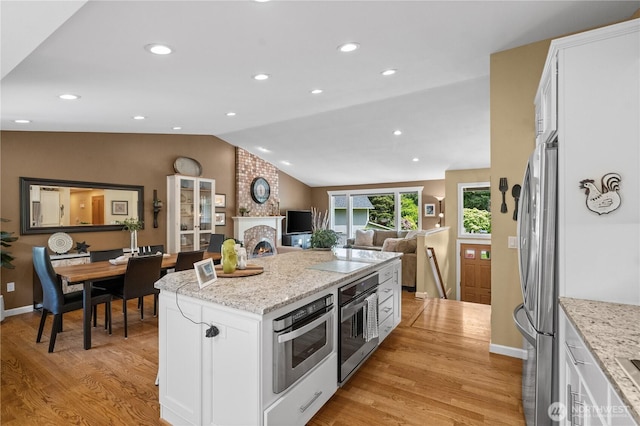 10811 164th Pl NE, Redmond, WA 98052 - kitchen featuring appliances with stainless steel finishes, lofted ceiling, light wood finished floors, white cabinetry, and a kitchen island